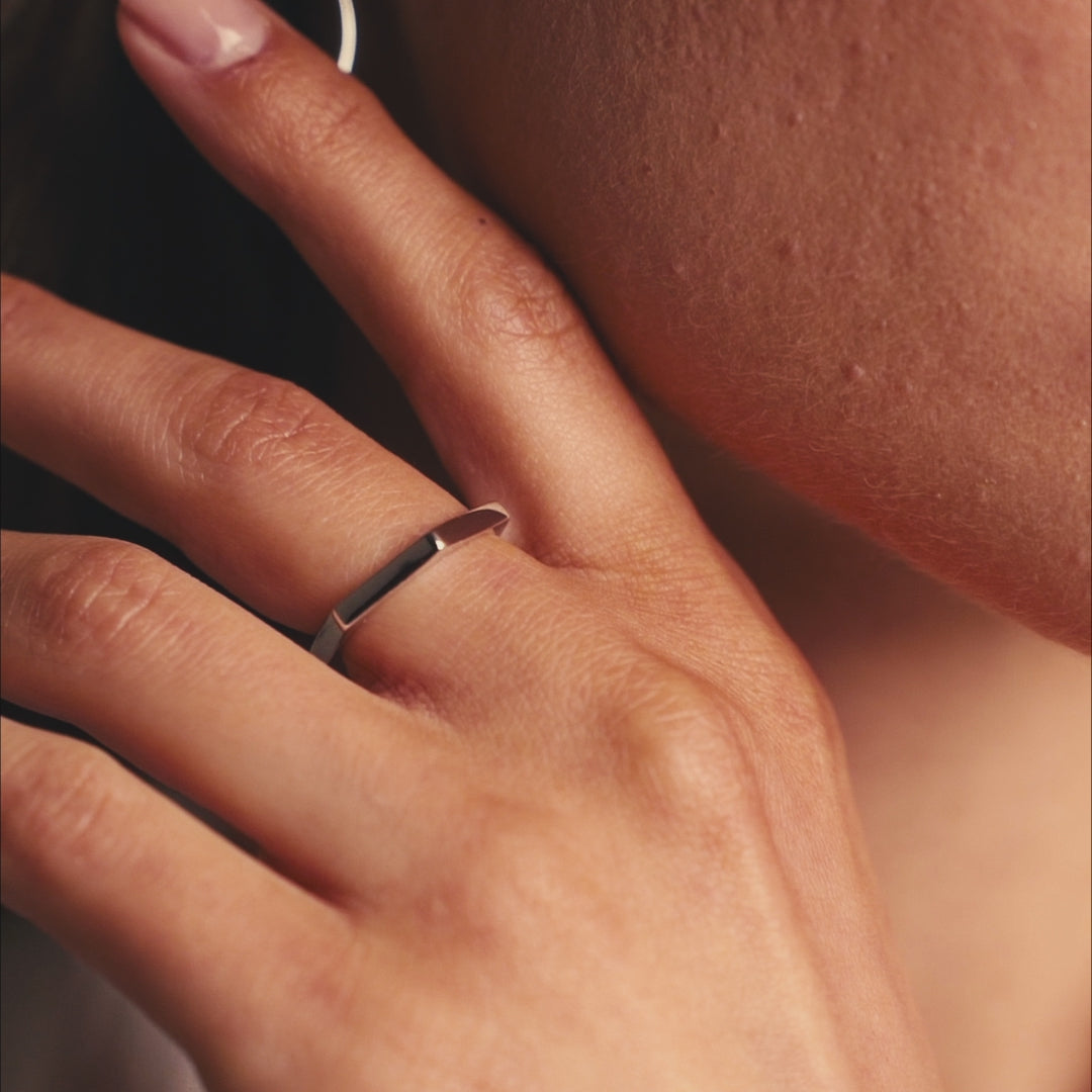 Il video mostra mani femminili in movimento che indossano un anello in argento 925 con finitura rodio e forma esagonale. Le riprese ravvicinate esaltano il design geometrico e minimale del gioiello, riflettendo la luce in modo sobrio ed elegante. Le mani si muovono con naturalezza su sfondo neutro, mettendo in risalto i dettagli della finitura lucida. L’atmosfera visiva è pulita e raffinata, focalizzata sulla semplicità e modernità del pezzo.